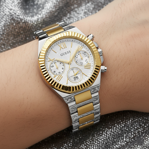 Close up shot of Guess GW0769L3 watch on wrist showing the silver sunray dial and gold coin-edge bezel