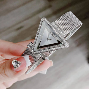 Woman wearing Guess Fame GW0508L1 silver triangle watch with a chic modern outfit