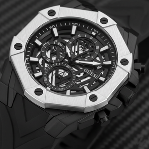 Close up shot of Guess Formula GW0579G1 watch on wrist showing the black mechanical dial and white bezel contrast