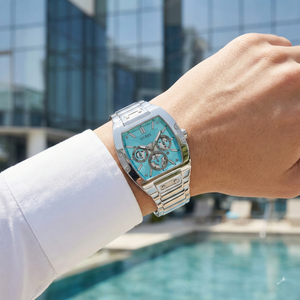 AI lifestyle shot of a man wearing the silver and Tiffany blue Guess Phoenix watch