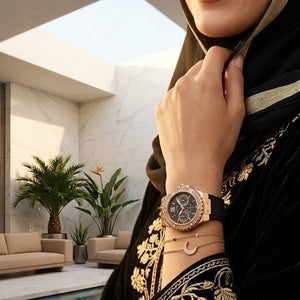Half-face lifestyle shot of a woman with fair skin wearing bracelets and rings on the same hand as the Guess Limelight black rubber watch for a sophisticated everyday look