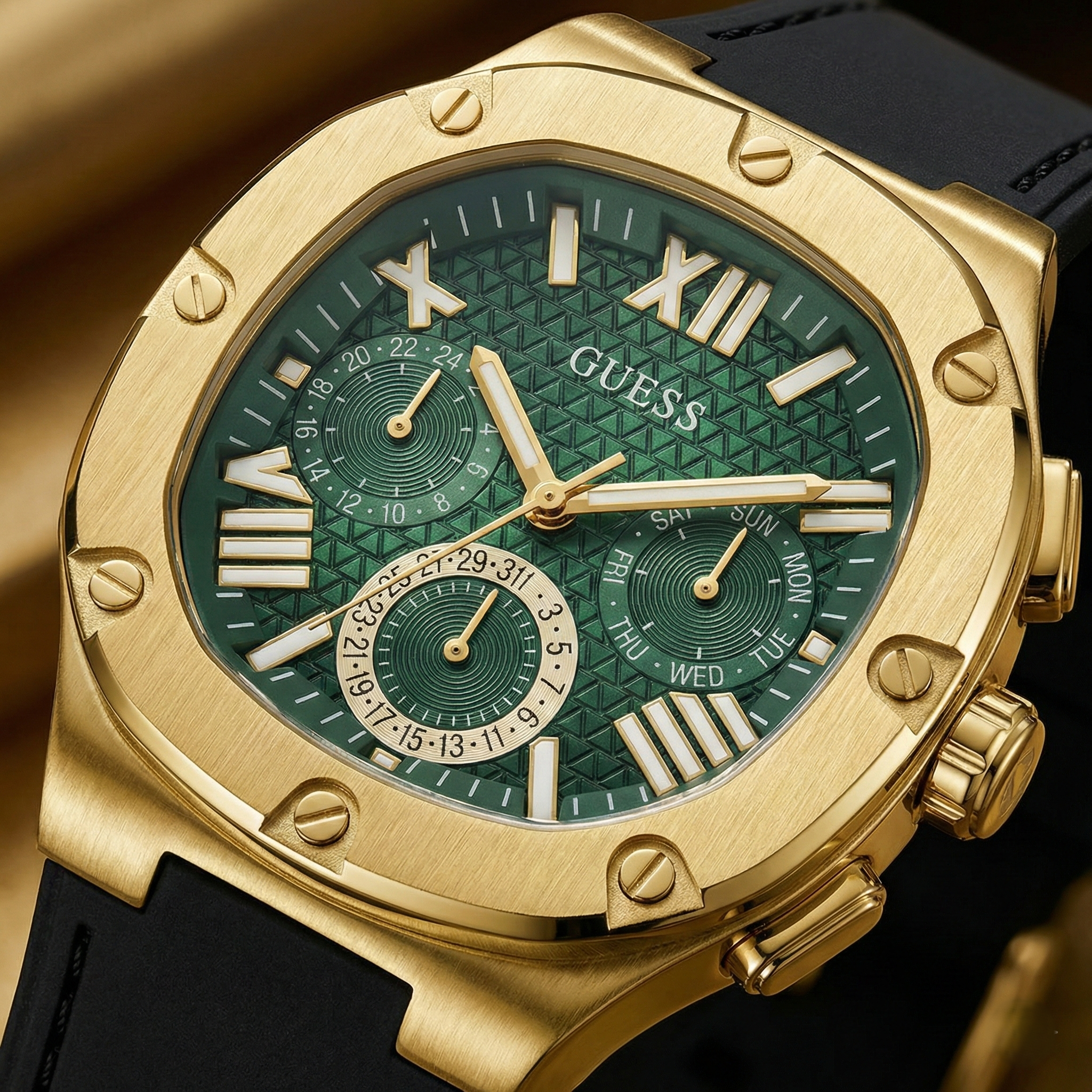 Close up shot of Guess GW0571G3 watch on wrist showing the green textured dial and gold bezel screws