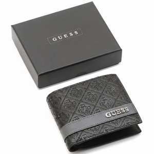 A closed Guess men's black leather bifold wallet with an embossed logo pattern and silver lettering, placed next to its matching black closed gift box