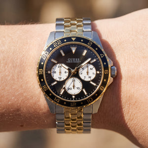 Wrist shot of Guess U1107G6M watch showing the two-tone metal band