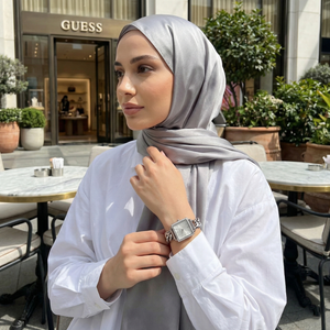 Woman wearing Guess Vanity W1030L1 silver square watch with a chic modern outfit