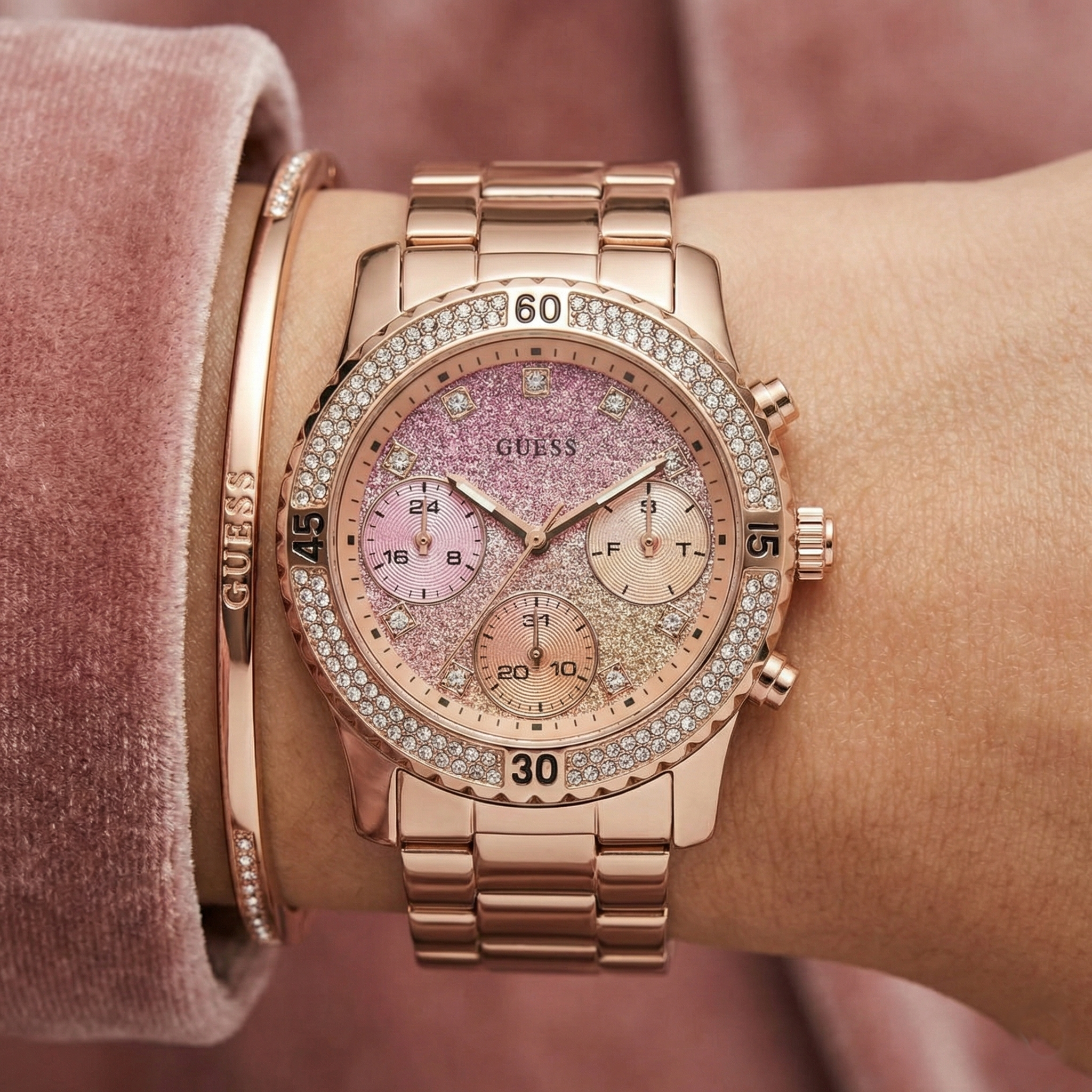 Close-up of Guess Confetti W0774L3 showing the pink glitter gradient dial and crystals