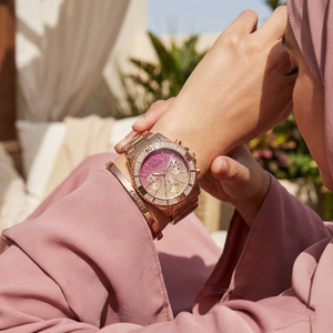 AI lifestyle shot of a woman wearing Guess Confetti W0774L3 rose gold watch