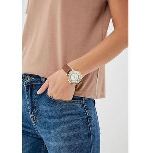 Female model wearing Guess W0934L3 gold watch with a chic casual outfit