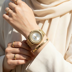 Female model wearing Guess Willow W0836L3 gold watch with a chic and elegant outfit