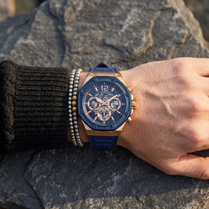 Close up of Guess Momentum GW0263G2 men's quartz battery watch on wrist showing clean blue dial and luxury blue geometric bezel