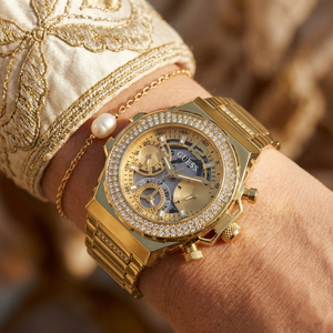 Close up of Guess Fusion GW0552L2 women's quartz battery watch on wrist showing intricate gold dial and luxury crystal bezel