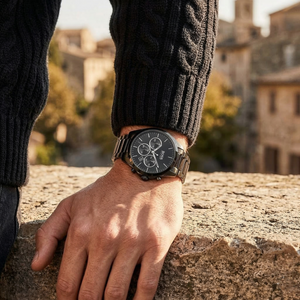 Half-face lifestyle shot of a man with fair skin wearing bracelets and rings on the same hand as the Hugo Boss Onyx black metal watch for a sophisticated everyday look