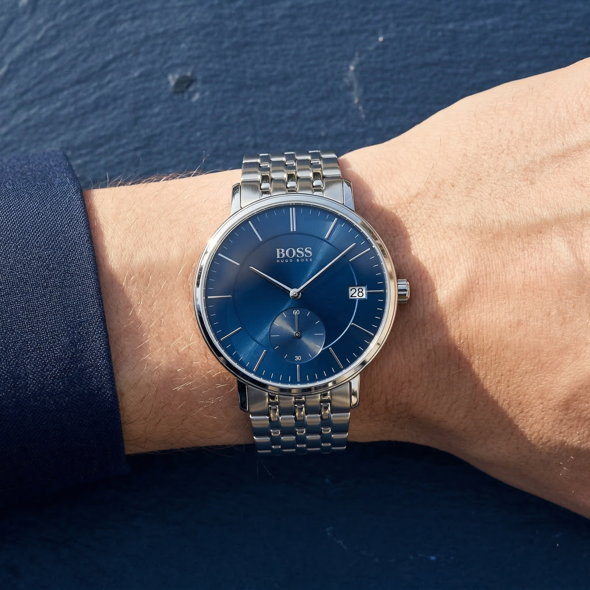 Half-face lifestyle shot of a man with fair skin wearing bracelets and rings on the same hand as the Hugo Boss Corporal silver metal watch for a sophisticated everyday look