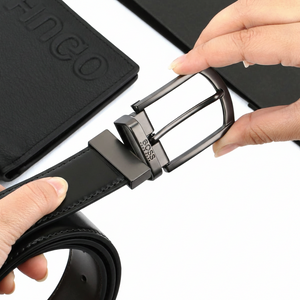 Close-up of a Hugo Boss black genuine leather belt featuring a polished silver-tone pin buckle with engraved branding