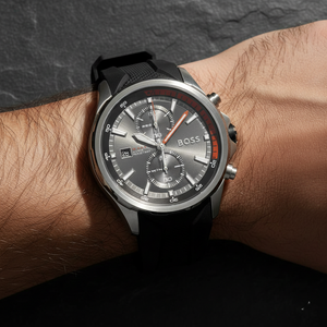 Close up shot of Hugo Boss Globetrotter 1513931 watch on wrist showing the grey dial and orange hands