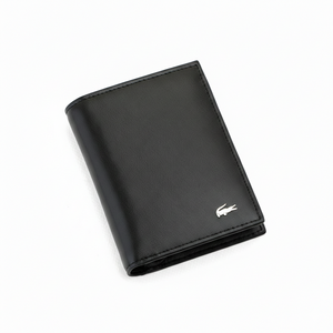 Angled high-perspective view of a closed Lacoste men's black smooth leather wallet showcasing the elegant silver metal crocodile hardware