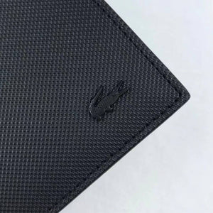 Close up detail of black metal Lacoste crocodile logo on signature Petit Piqué textured leather