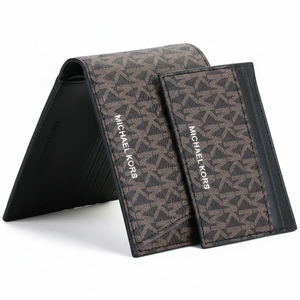Perspective view of a standing Michael Kors men's brown monogram bifold wallet with its matching cardholder leaning against it, highlighting the metal logo lettering