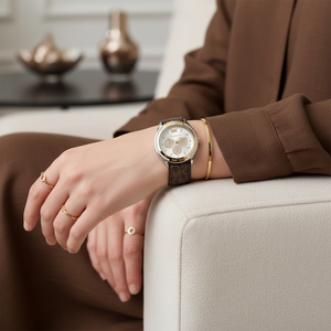 Lifestyle shot of a woman's wrist wearing the Michael Kors MK7205 two-tone watch with the branded brown rubber strap