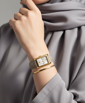 Modest woman wearing Michael Kors MK4964 gold rectangular leather watch on hairless wrist