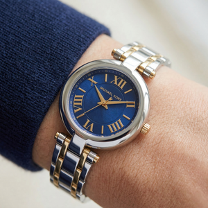 Close up of Michael Kors Lennox MK01085 on wrist showing blue mother of pearl dial and two-tone metal bracelet with 50m water resistance