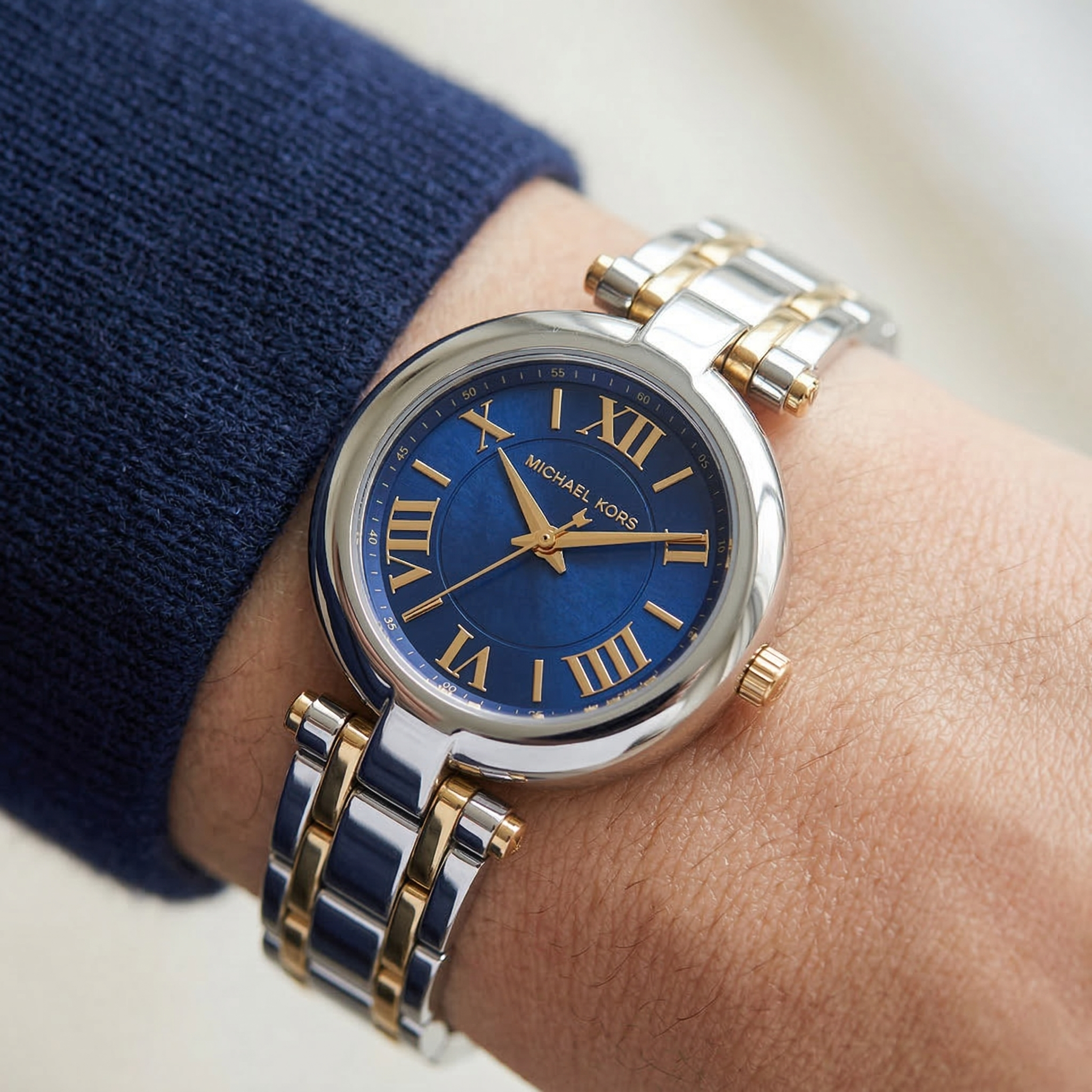 Close up of Michael Kors Lennox MK01085 on wrist showing blue mother of pearl dial and two-tone metal bracelet with 50m water resistance