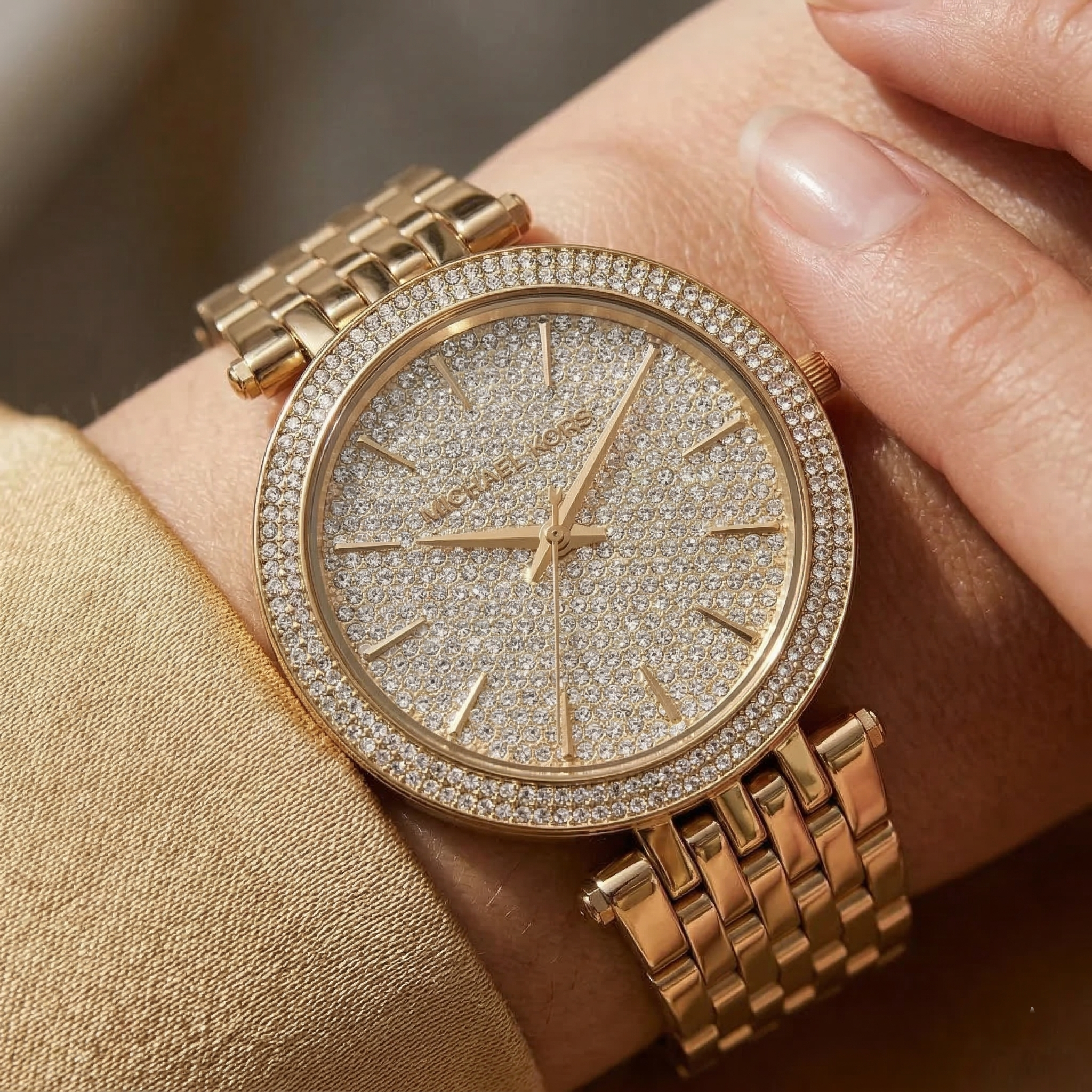 Close up of Michael Kors Darci MK3438 on wrist showing full pavé crystal dial and gold metal bracelet with 50m water resistance