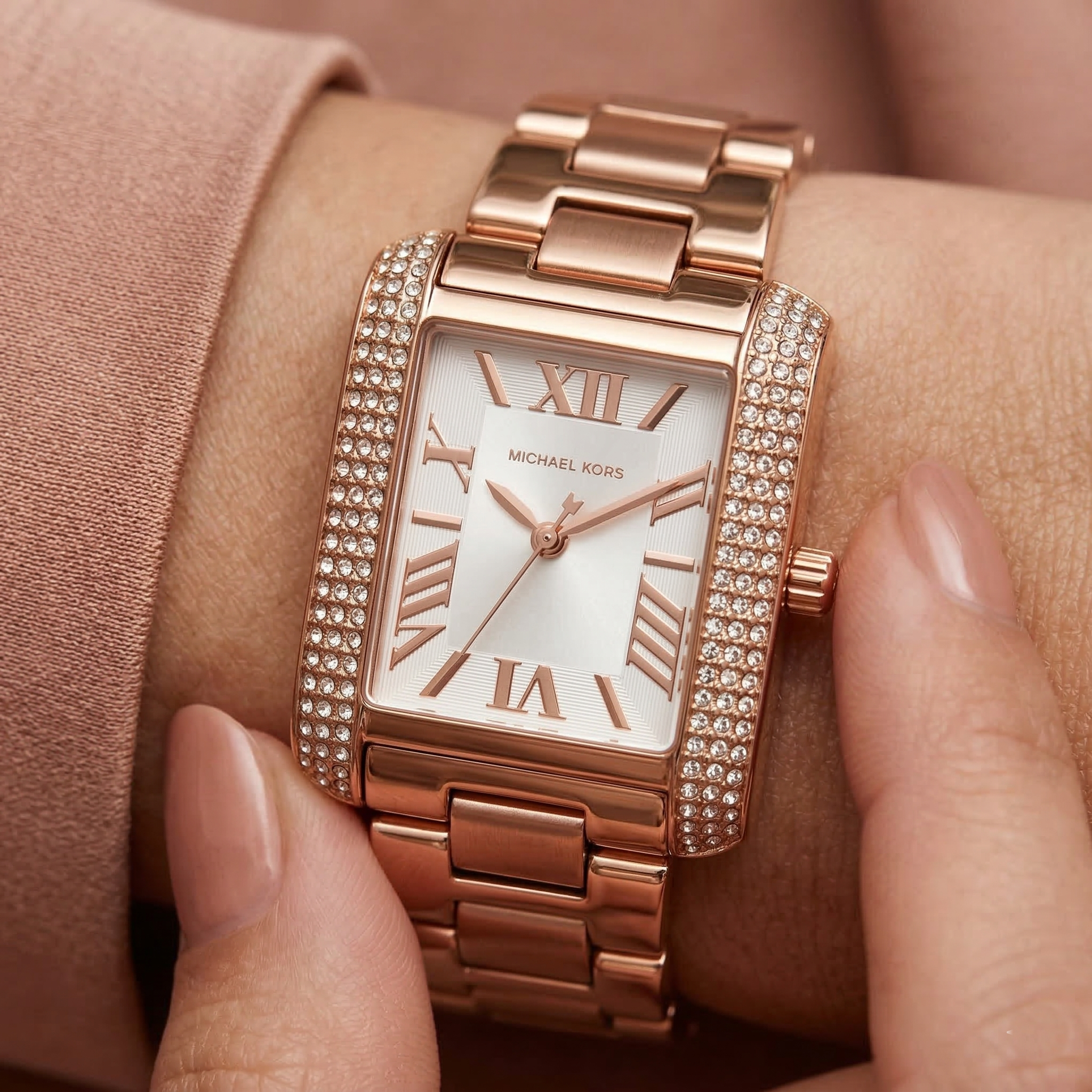 Close up of Michael Kors Emery MK4641 on wrist showing rectangular crystal pave case and rose gold metal bracelet with 50m water resistance