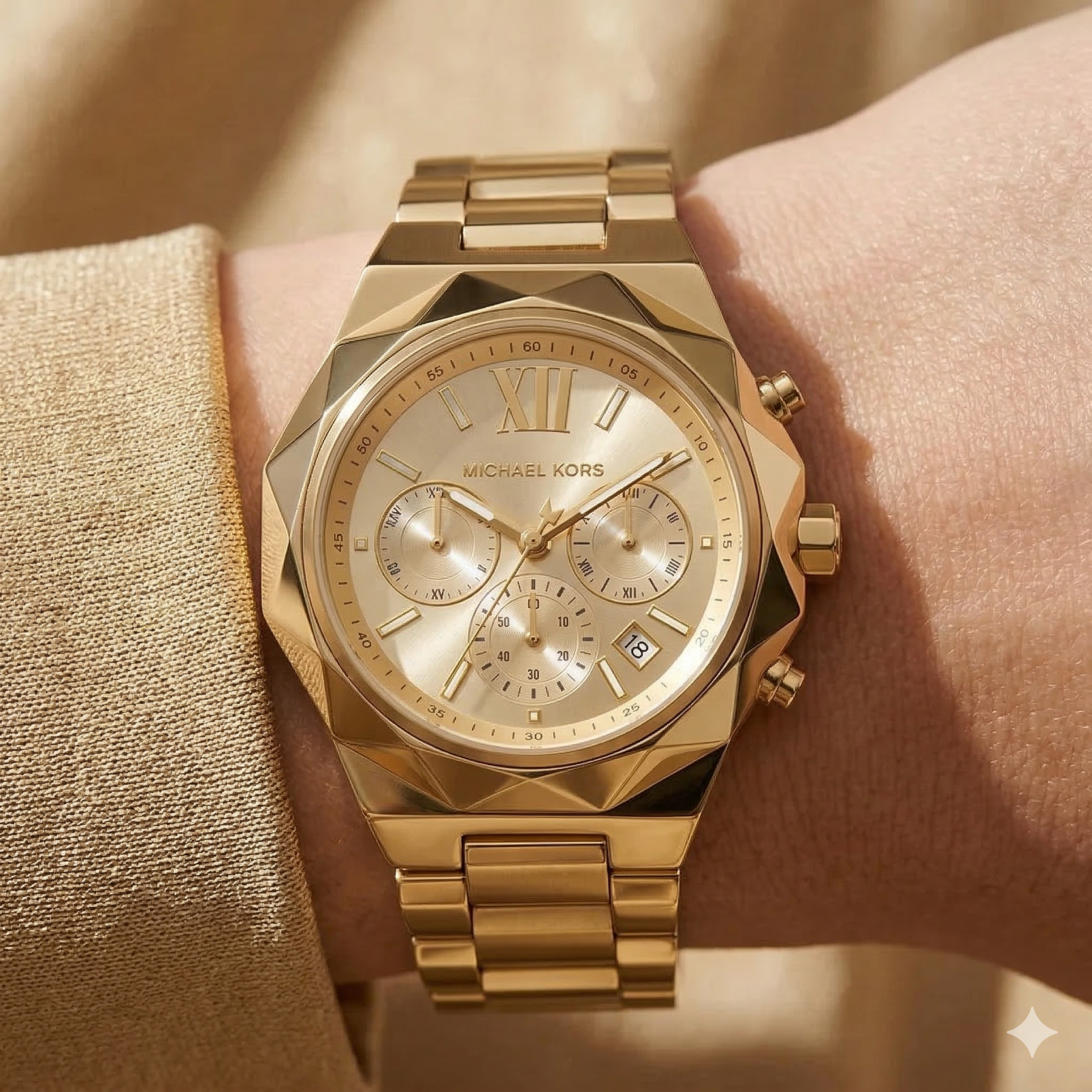 Close up of Michael Kors Raquel MK4690 women's quartz battery watch on wrist showing gold sunray dial and faceted metal case