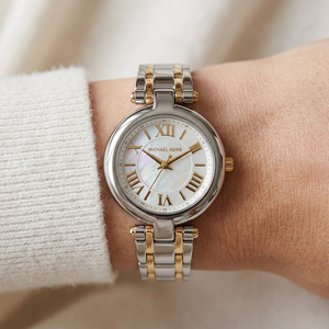 Close up of Michael Kors Lennox MK4895 on wrist showing white mother of pearl dial and two-tone metal bracelet with 50m water resistance