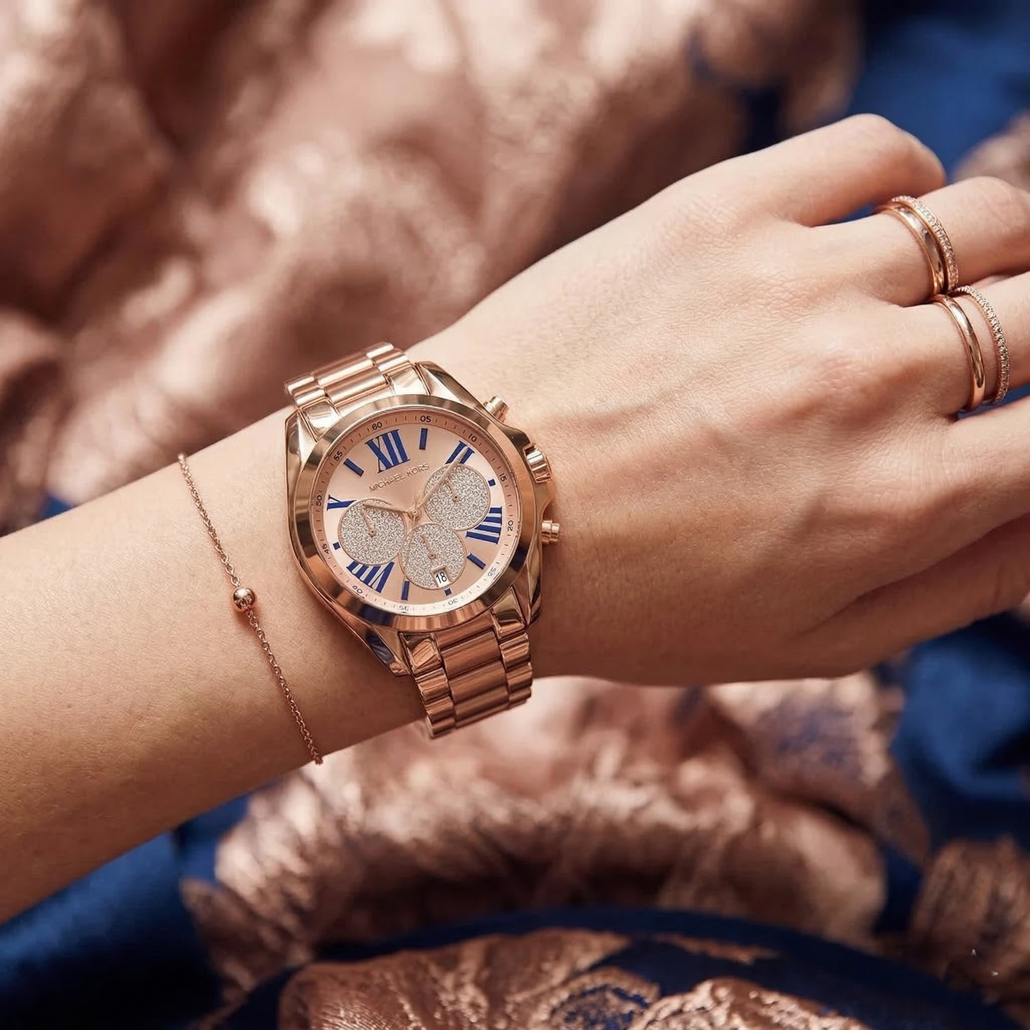 Close up of Michael Kors Bradshaw MK6321 women's quartz battery watch on wrist showing pavรฉ crystal sub-dials and blue Roman numerals