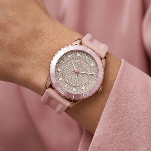 Close up of Michael Kors Runway MK6854 women's quartz battery watch on wrist showing full pavé crystal dial and pink rubber strap