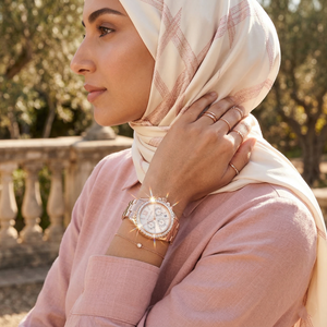 Elegant woman wearing Michael Kors Everest MK7213 women's quartz battery watch with rose gold-tone case and luxury crystal bezel