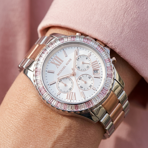 Close up of Michael Kors Everest MK7214 women's quartz battery watch on wrist showing white dial and brilliant rose baguette crystal bezel