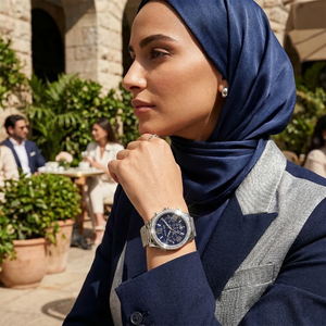 Elegant woman wearing Michael Kors Lexington MK7277 women's quartz battery watch with silver-tone case and luxury navy glitter dial