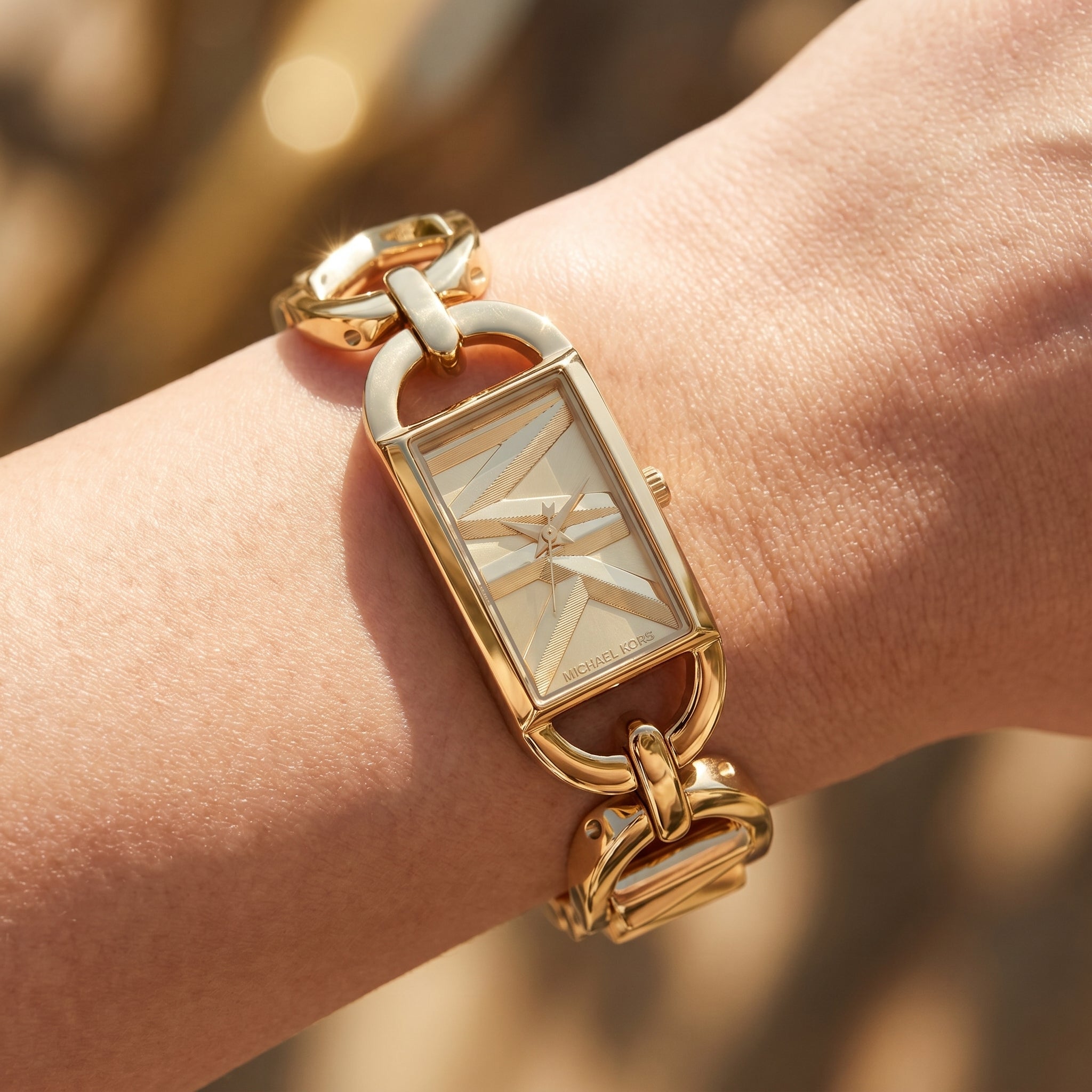 Close up shot of Michael Kors MK7406 on wrist showing the gold rectangular case and chain bracelet