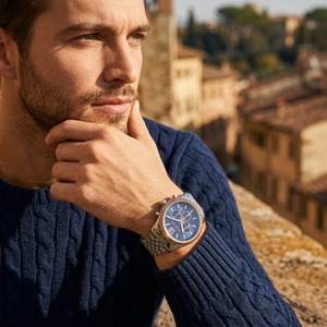 Elegant man wearing Michael Kors Lexington MK8689 men's quartz battery watch with silver-tone case and luxury rose gold fluted bezel