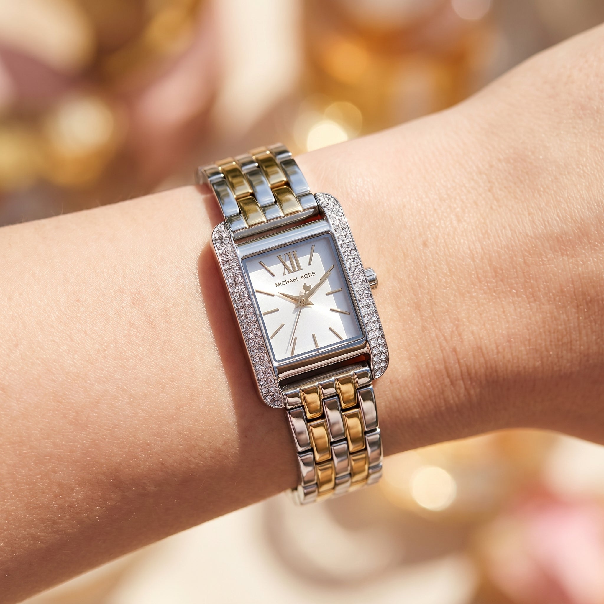 Close up shot of Michael Kors MKO1035 on wrist showing the silver and gold case with white dial