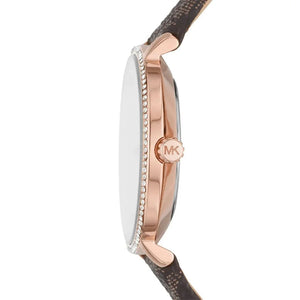 Side profile of a Michael Kors watch with a rose gold case, crystal-embellished bezel, and a brown textured strap on a white background.