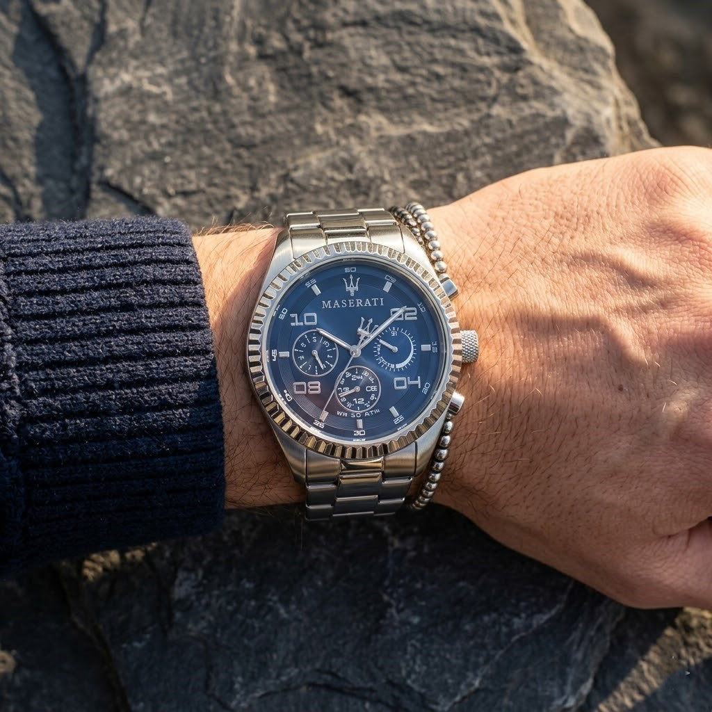 Close up of Maserati Competizione R8853100011 men's quartz battery watch on wrist showing blue multi-function dial and silver metal bracelet