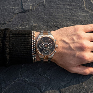 Close up of Maserati Competizione R8853100020 men's quartz battery watch on wrist showing black sunray dial and two-tone metal bracelet