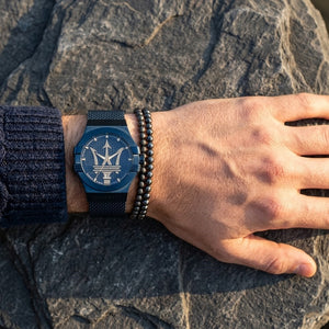 Close up of Maserati Potenza R8853108008 men's quartz battery watch on wrist showing gold Trident logo and blue mesh strap