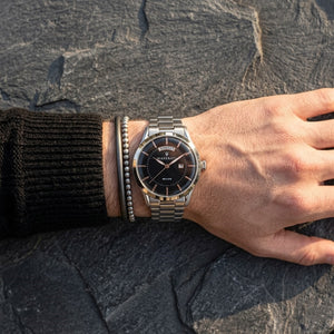Close up of Maserati Tradizione R8853125002 men's quartz battery watch on wrist showing black dial and silver metal bracelet