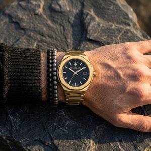Close up of Maserati Stile R8853142004 men's quartz battery watch on wrist showing black waffle dial and luxury gold case
