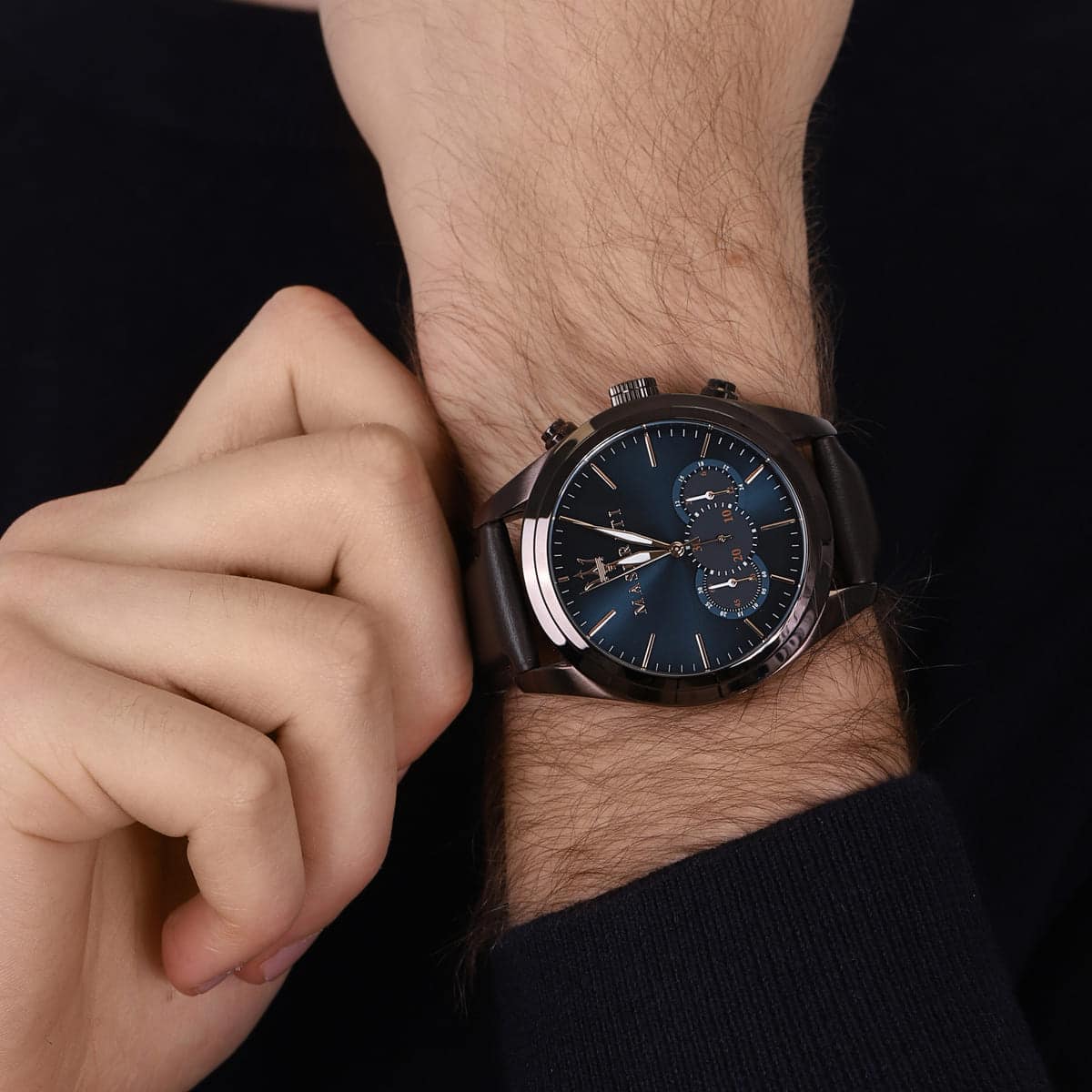 Close up of Maserati Traguardo R8871612008 men's quartz battery watch on wrist showing blue sunray dial and brown leather strap