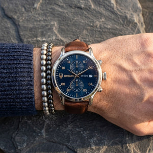 Close up of Maserati Epoca R8871618001 men's quartz battery watch on wrist showing blue sunray dial and brown leather strap