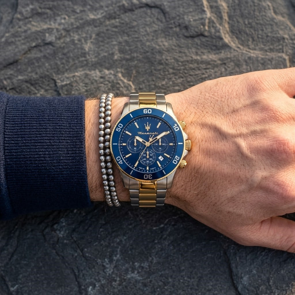 Close up of Maserati Competizione R8873600006 men's quartz battery watch on wrist showing blue chronograph dial and two-tone metal bracelet
