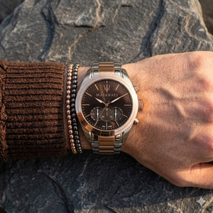Elegant man wearing Maserati Traguardo R8873612003 men's quartz battery watch with two-tone case and luxury brown dial