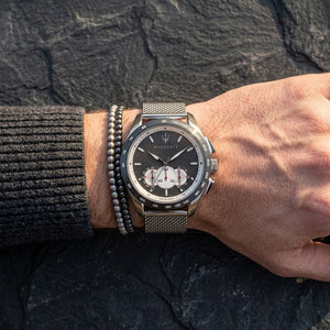 Close up of Maserati Traguardo R8873612008 men's quartz battery watch on wrist showing gray textured dial and silver mesh strap