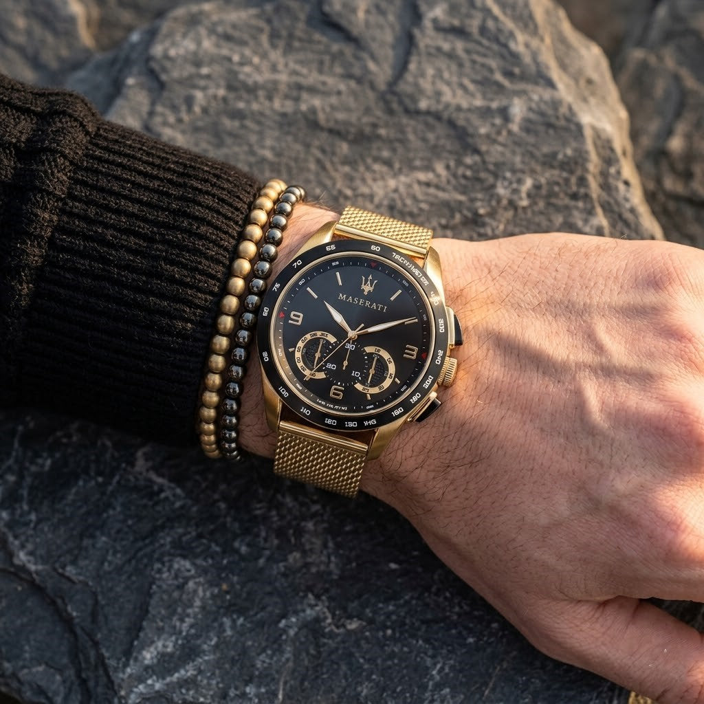 Close up of Maserati Traguardo R8873612010 men's quartz battery watch on wrist showing black sunray dial and gold mesh metal strap